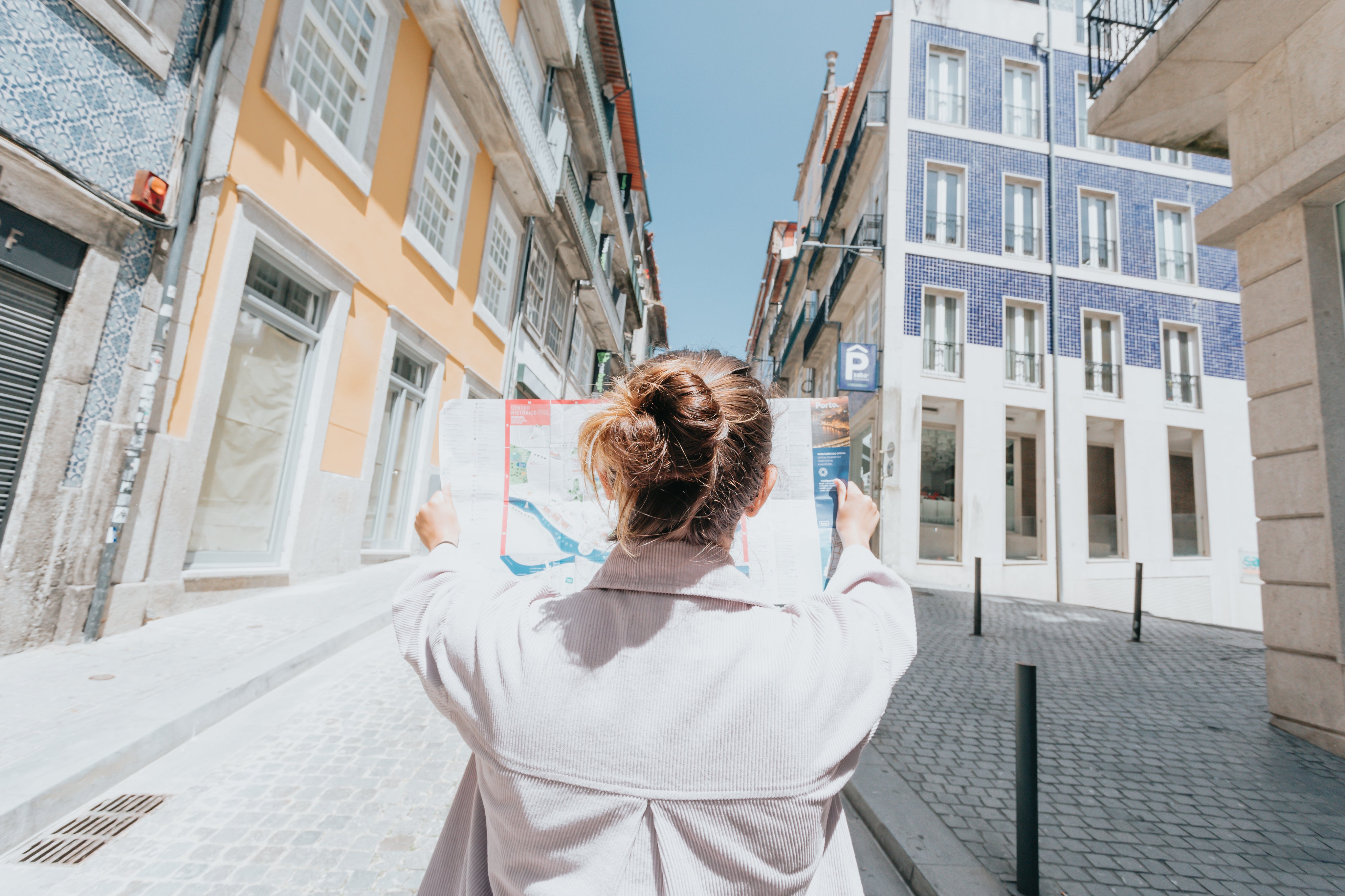 person-holds-up-map-while-standing-on-a-city-street.jpg